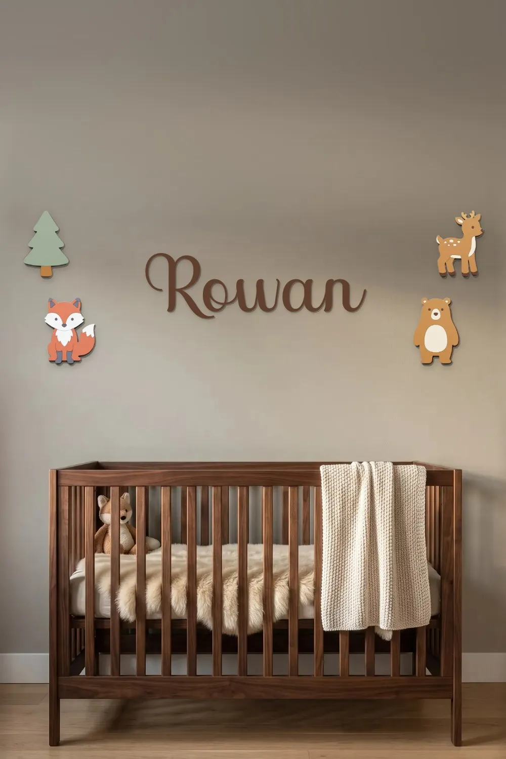 Rowan woodland name sign in chocolate brown with a pine tree, fox, bear and deer above a walnut crib